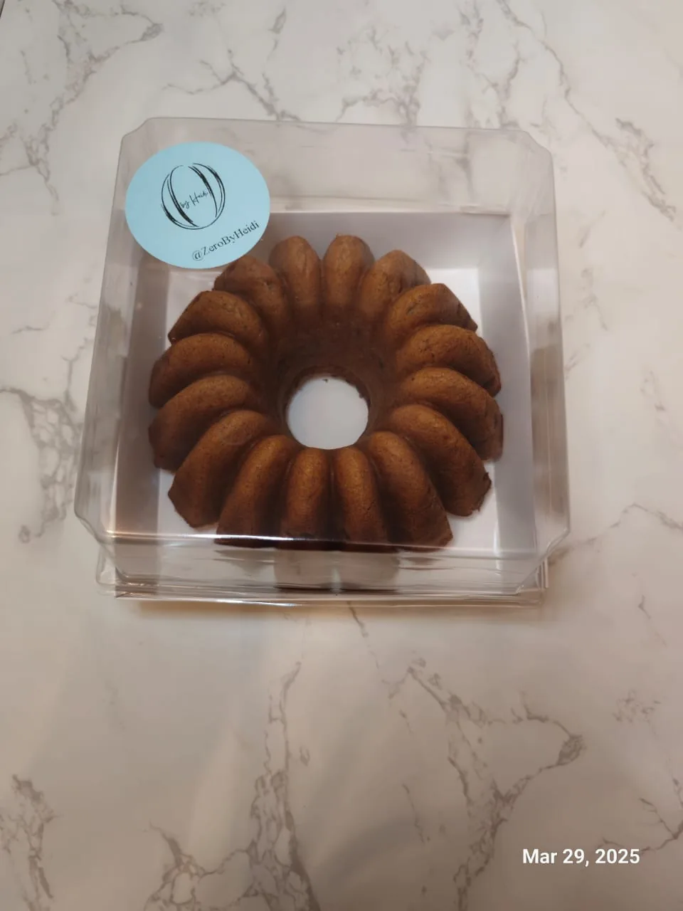 A bundt cake in a clear takeaway box